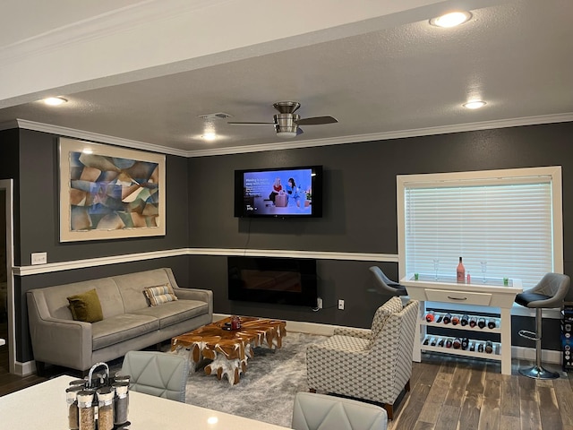 living room featuring dark hardwood / wood-style floors, ceiling fan, and ornamental molding