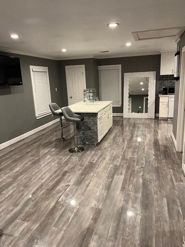 dining area featuring ornamental molding, dark hardwood / wood-style flooring, and indoor wet bar