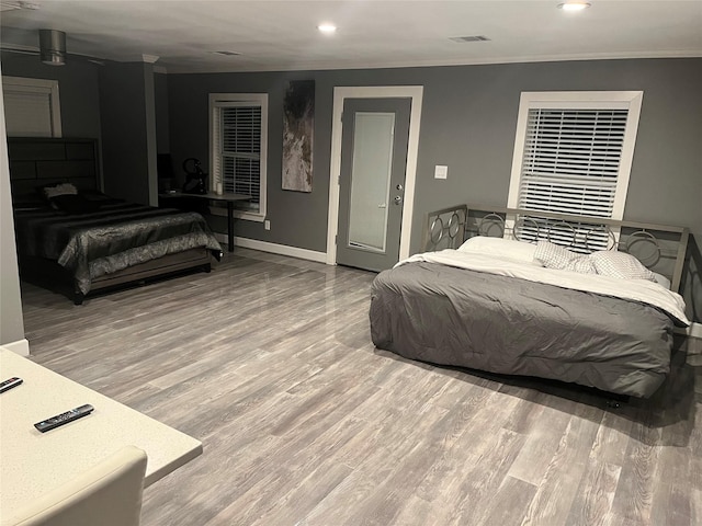 bedroom featuring wood-type flooring and ornamental molding