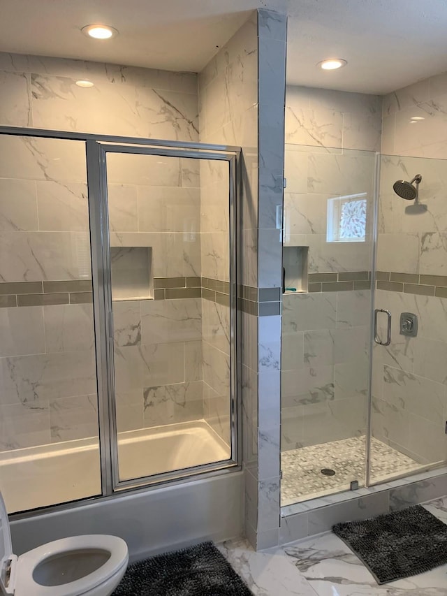 bathroom with toilet and bath / shower combo with glass door