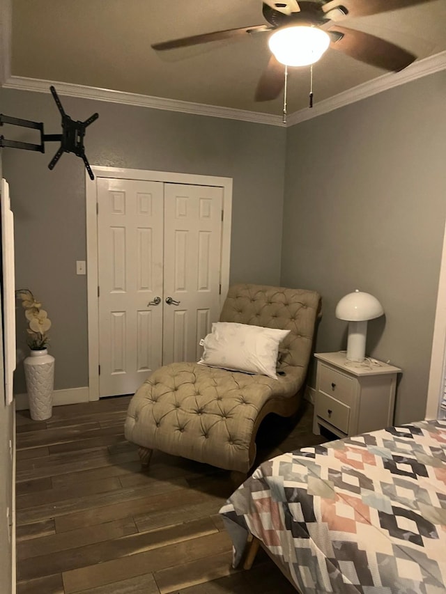 bedroom with a closet, dark hardwood / wood-style floors, ceiling fan, and ornamental molding