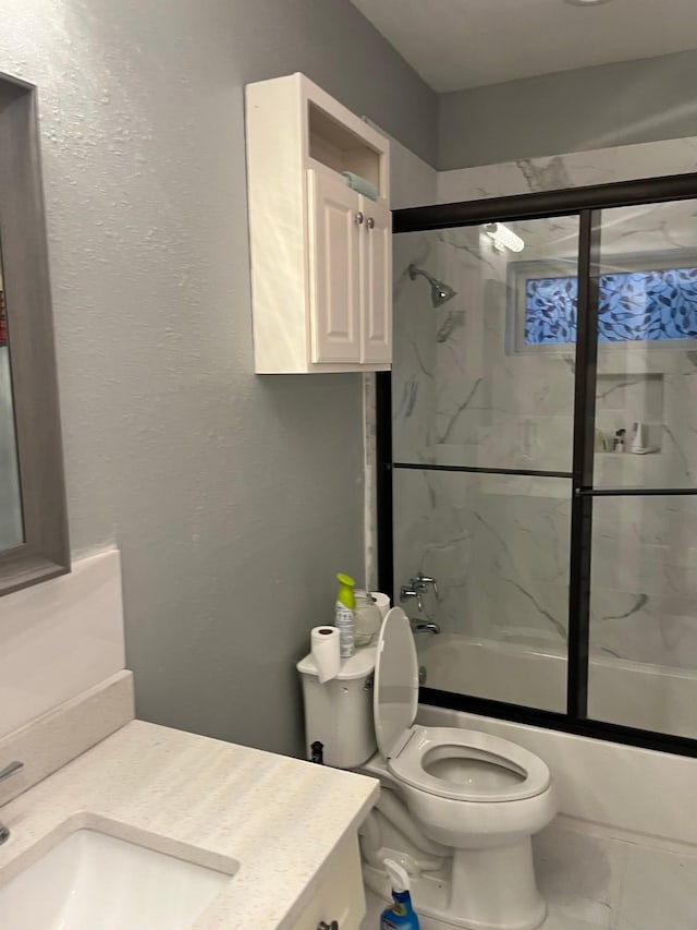 full bathroom with shower / bath combination with glass door, vanity, and toilet