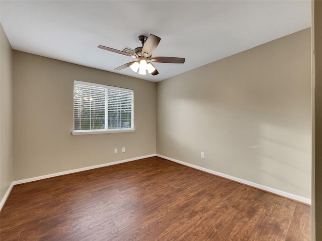 empty room with ceiling fan and dark hardwood / wood-style flooring