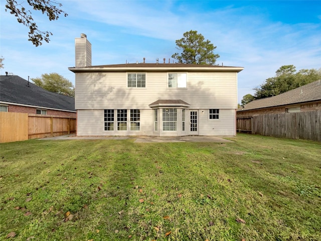 rear view of property with a lawn and a patio area