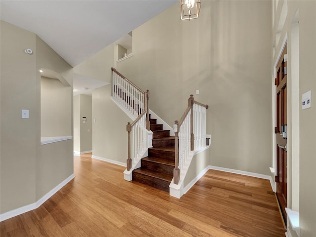 entrance foyer with an inviting chandelier, a high ceiling, and light wood-type flooring