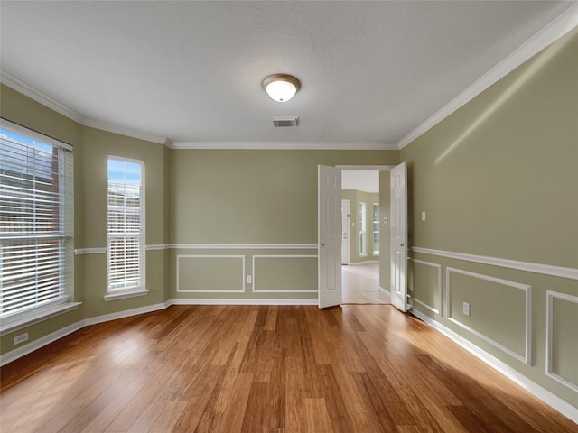 unfurnished room featuring light hardwood / wood-style floors and ornamental molding