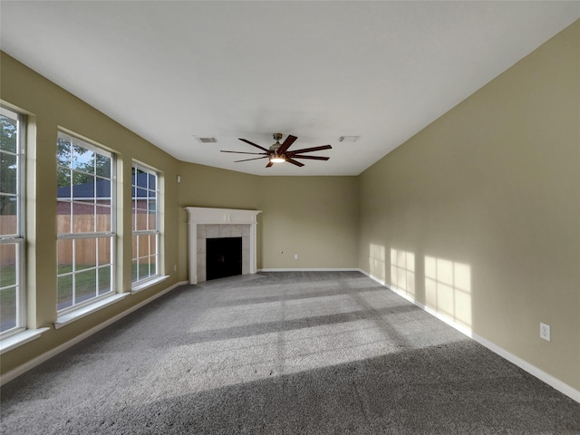 unfurnished living room featuring carpet, a tile fireplace, and ceiling fan