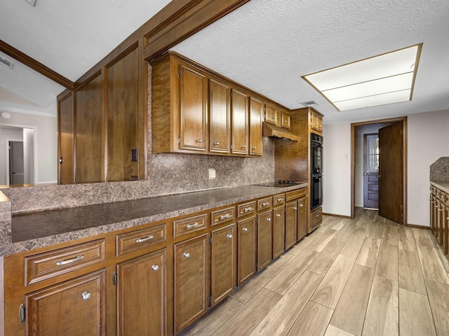 kitchen with decorative backsplash, light wood-type flooring, a textured ceiling, black appliances, and lofted ceiling