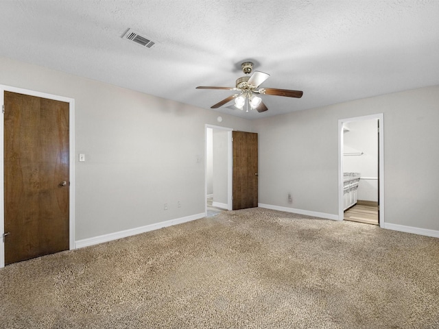 unfurnished bedroom with connected bathroom, light colored carpet, and ceiling fan