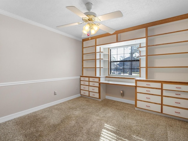 interior space with ceiling fan, ornamental molding, a textured ceiling, built in desk, and light colored carpet