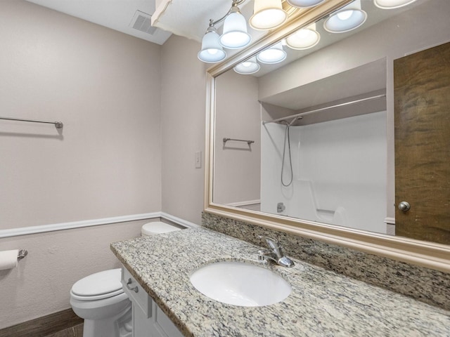 bathroom with a shower, vanity, and toilet