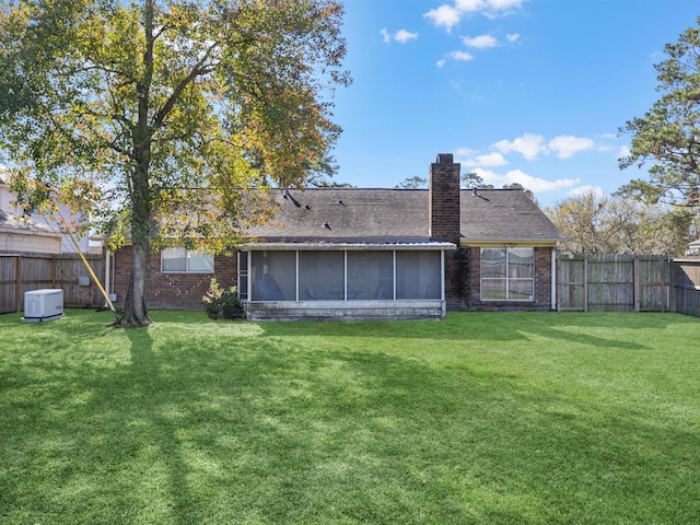 rear view of house with a sunroom and a yard