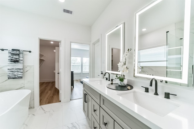 bathroom with a washtub and vanity