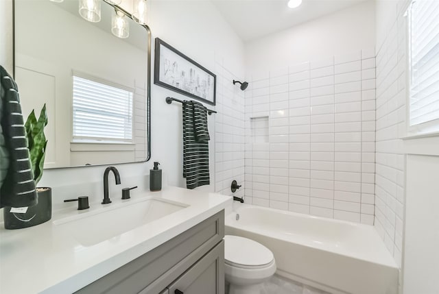 full bathroom with vanity, tiled shower / bath, and toilet