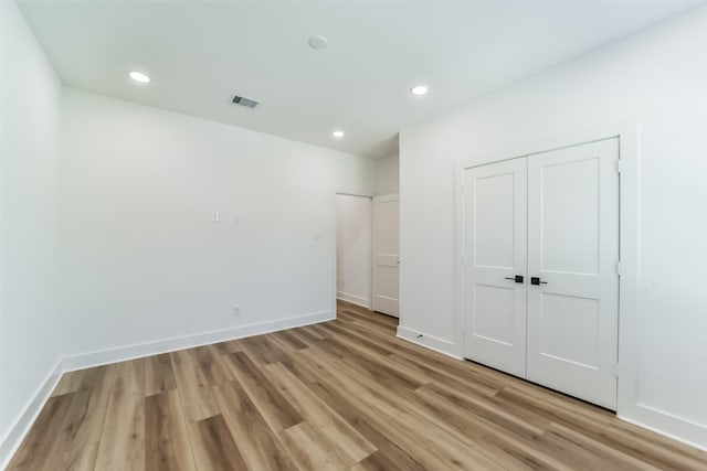 unfurnished bedroom featuring light hardwood / wood-style floors and a closet