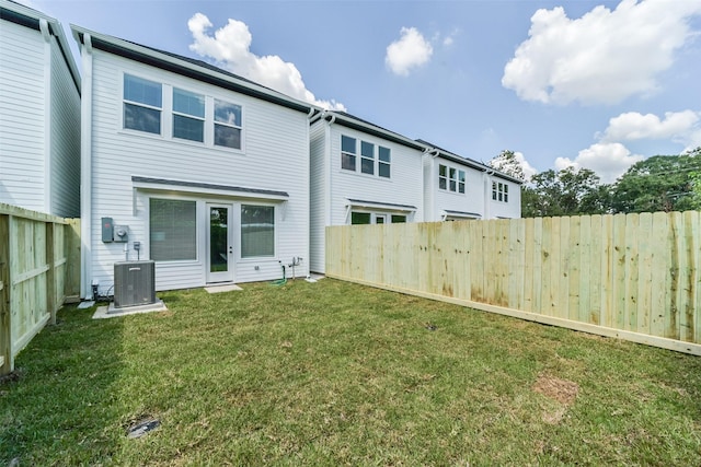 back of property featuring central AC unit and a lawn