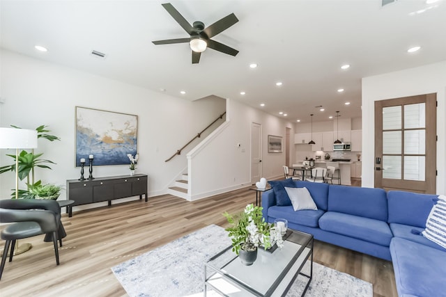 living room featuring ceiling fan and light hardwood / wood-style flooring