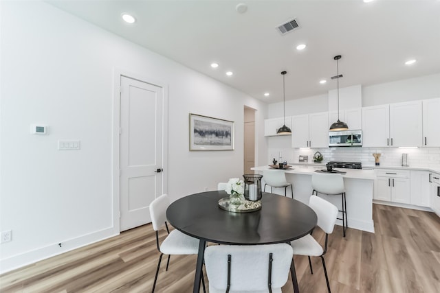 dining space with light hardwood / wood-style flooring