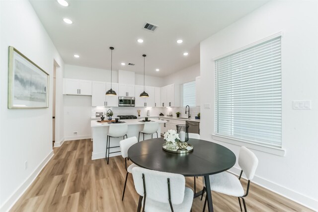 dining area with light wood-type flooring and sink