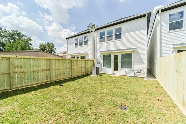 rear view of property with a yard and central air condition unit