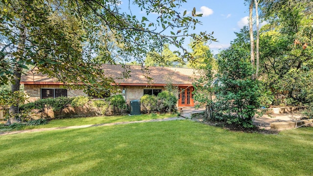 exterior space with central AC and a front yard