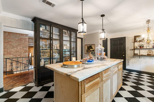 kitchen featuring pendant lighting, crown molding, light brown cabinetry, and a kitchen island