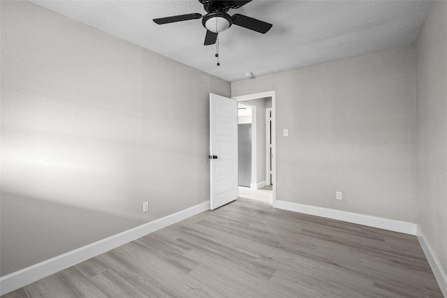 unfurnished room with ceiling fan, a textured ceiling, and light hardwood / wood-style flooring