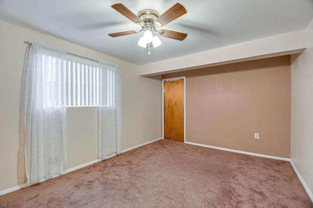 carpeted spare room featuring ceiling fan