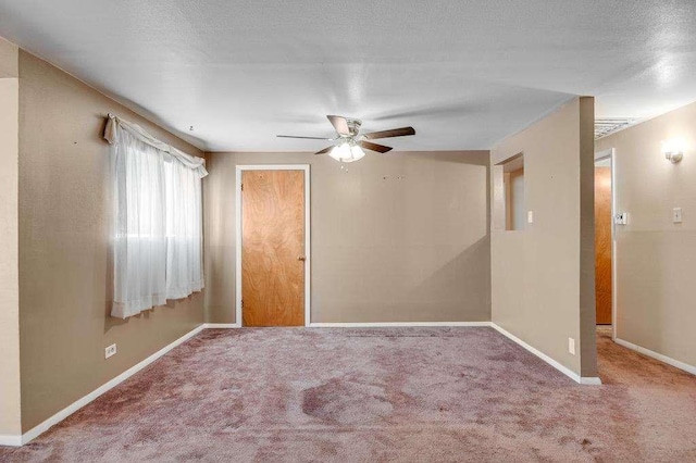 carpeted empty room with ceiling fan and a textured ceiling