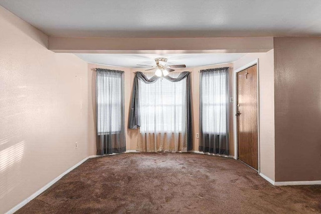 empty room featuring ceiling fan, beam ceiling, and carpet floors