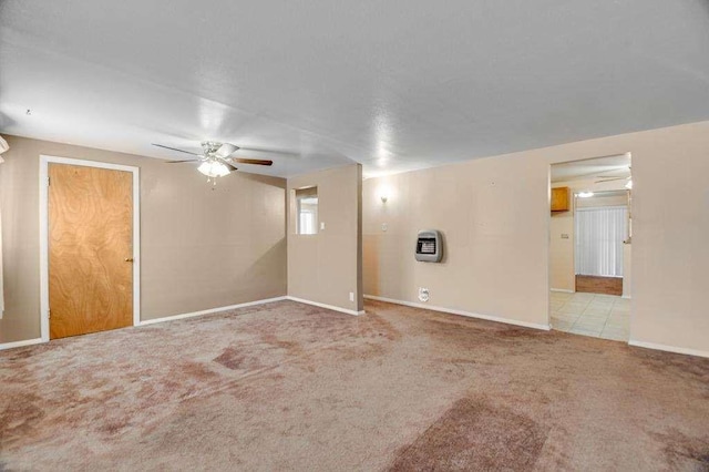 carpeted empty room featuring heating unit and ceiling fan