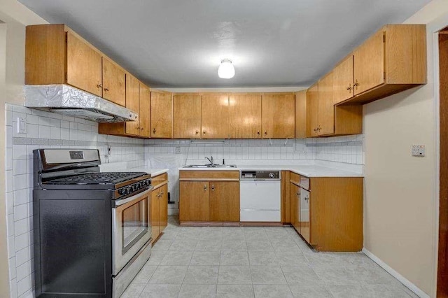 kitchen with stainless steel gas stove, white dishwasher, tasteful backsplash, and sink