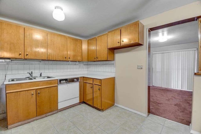 kitchen with dishwasher, light colored carpet, sink, and tasteful backsplash