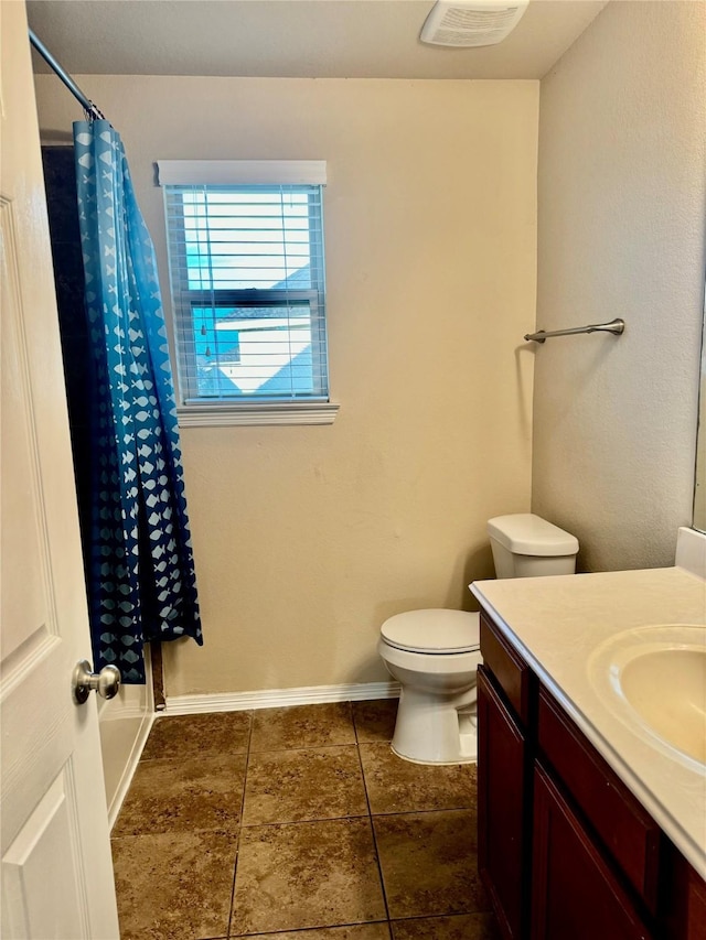 bathroom featuring curtained shower, vanity, and toilet