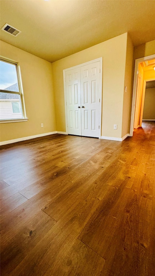 unfurnished bedroom featuring wood-type flooring and a closet