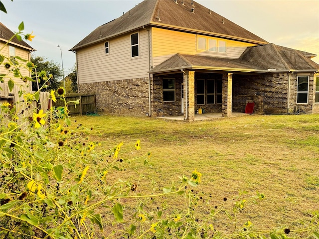 rear view of property with a patio area and a lawn