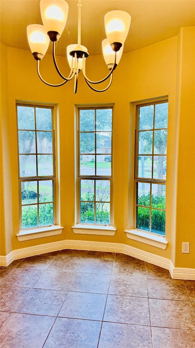 interior space featuring tile patterned flooring, a healthy amount of sunlight, and an inviting chandelier