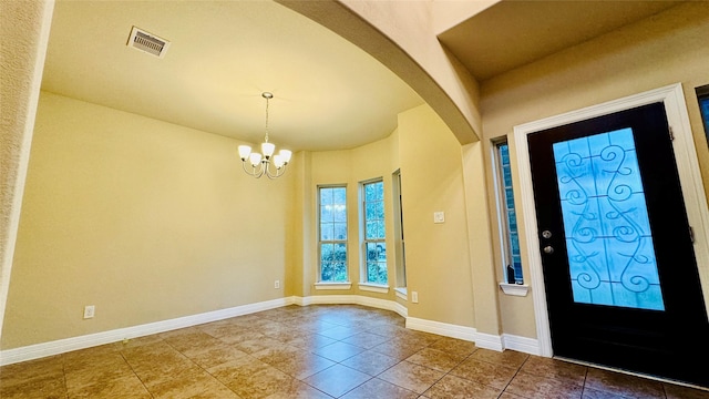 tiled entrance foyer featuring an inviting chandelier