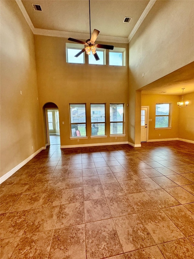 unfurnished living room with ceiling fan with notable chandelier, a high ceiling, and ornamental molding