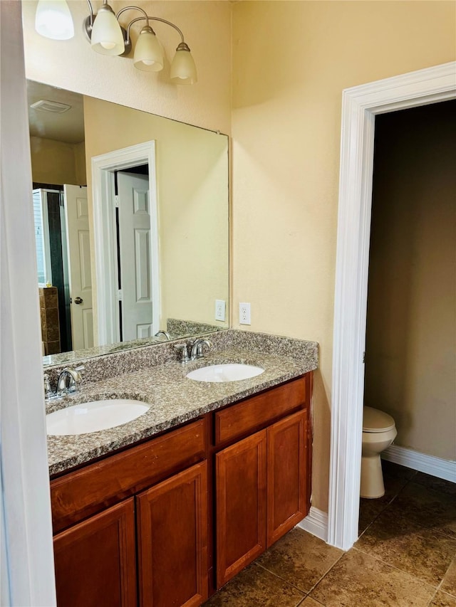 bathroom with tile patterned flooring, vanity, and toilet