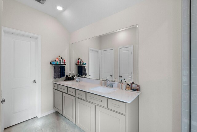 bathroom featuring tile patterned flooring, vanity, and lofted ceiling