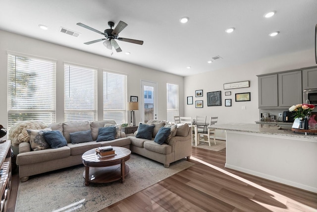 living room featuring dark hardwood / wood-style floors and ceiling fan