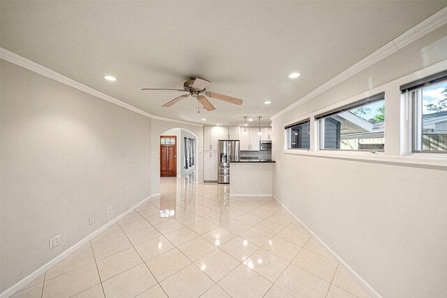 unfurnished living room with ceiling fan, light tile patterned floors, and ornamental molding