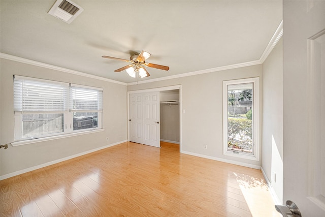 unfurnished bedroom featuring a closet, ceiling fan, crown molding, and light wood-type flooring