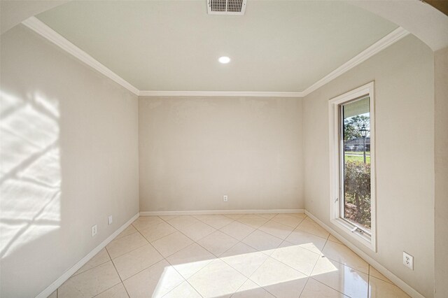 empty room with light tile patterned floors and crown molding