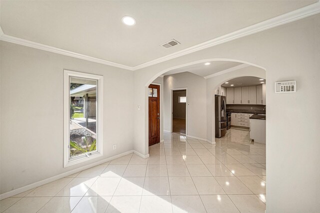 empty room with light tile patterned floors and ornamental molding