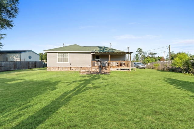 back of property with a wooden deck and a yard