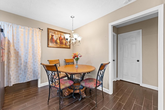 dining space featuring dark hardwood / wood-style flooring and a chandelier