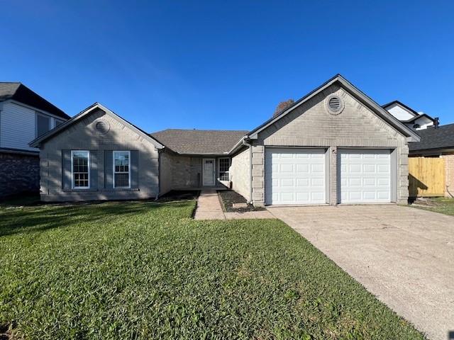 ranch-style house featuring a front yard and a garage