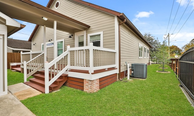 view of side of property with central AC and a lawn